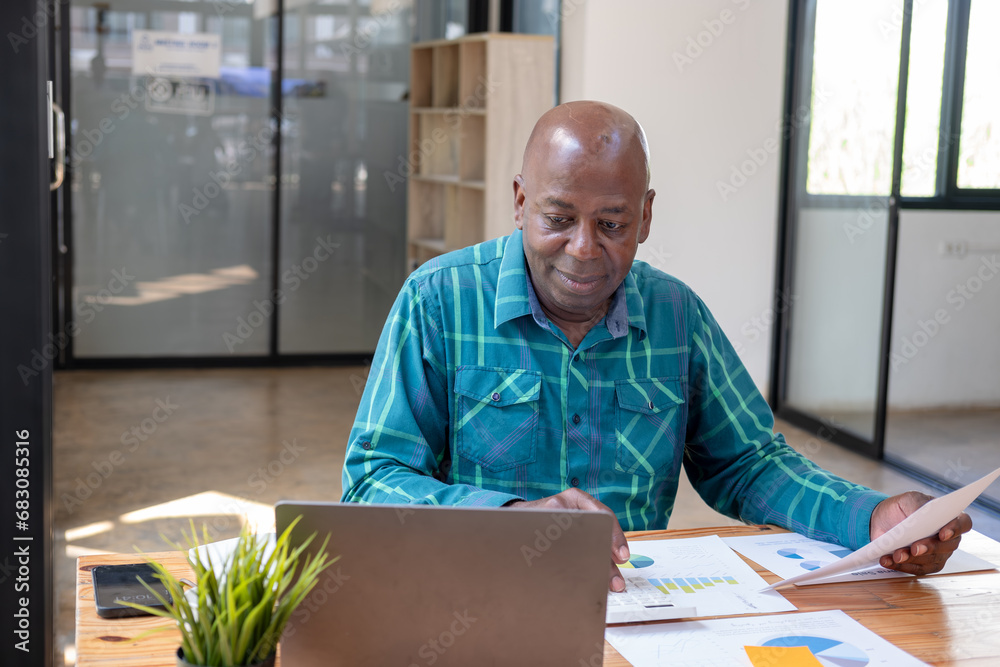 Young business man working at home with laptop and papers on desk Young business man working at home with laptop and papers on desk