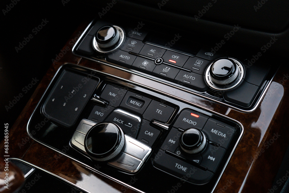 Fototapeta premium Interior of modern luxury car. Details of automatic transmission gear shift, multimedia control system, car control panel, Air Vent Red emergency button and dashboard inside. Prestige sport automobile