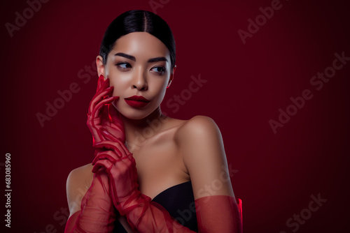 Photo of gorgeous asian young lady femme fatale touch cheek sexy look shoulders off isolated dark red color background