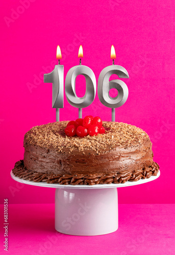 Number 106 candle - Chocolate cake on pink background