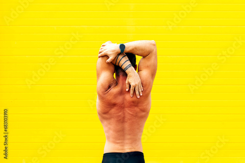 Shirtless muscular man exercising over wall photo