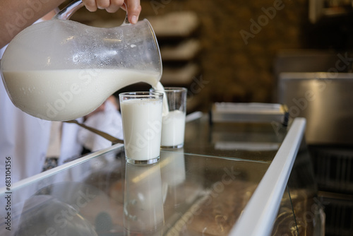 Unrecognizable person pouring milk into a glass photo