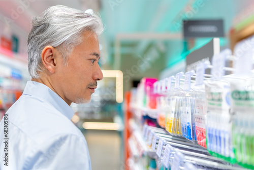 Calm senior man choosing products in drugstore photo