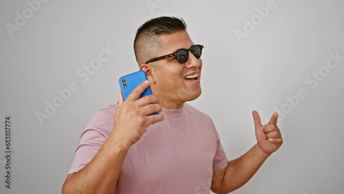 Young latin man dancing listening to music on smartphone over isolated white background