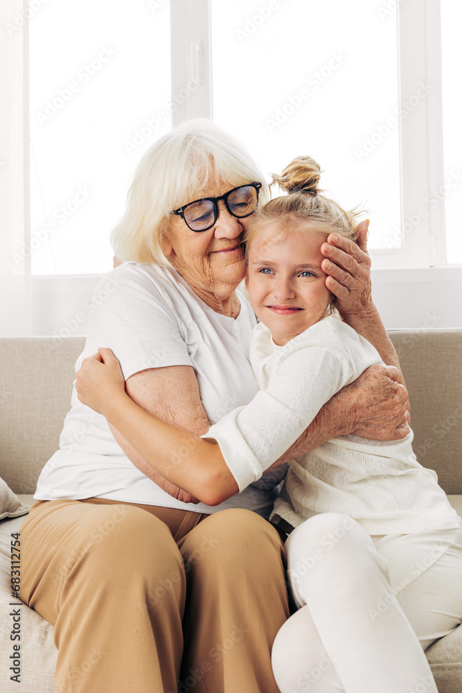 Woman happy couch grandmother love sofa granddaughter hugging home family girl bonding child