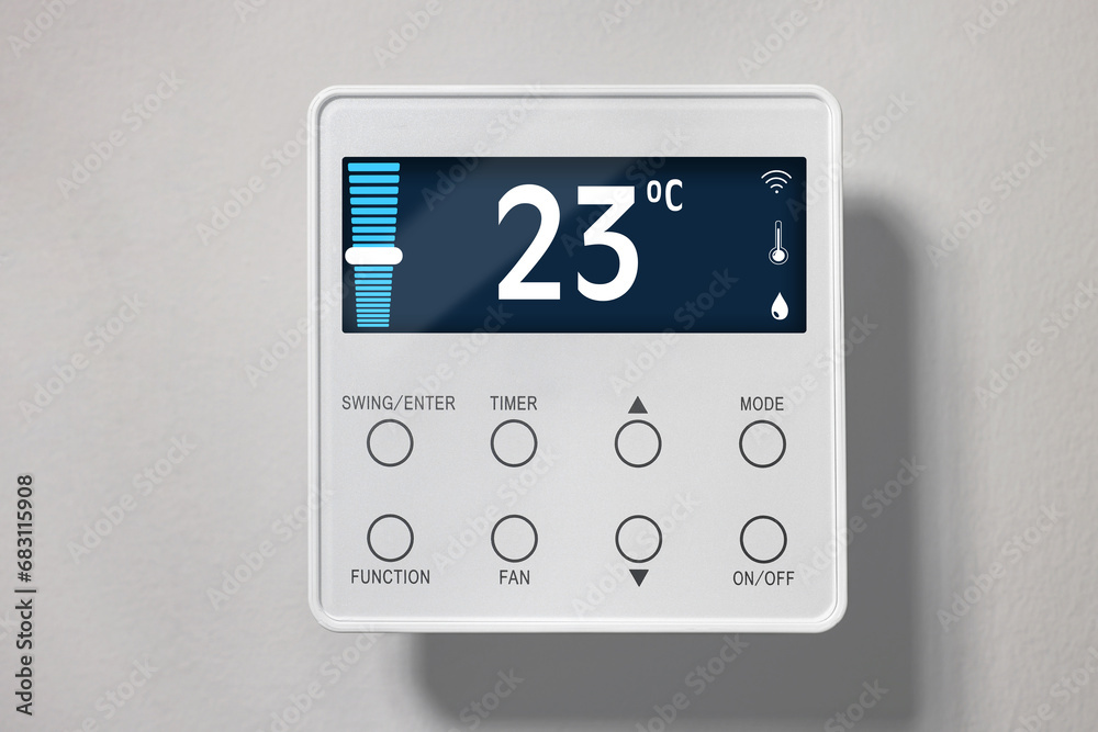 Thermostat displaying temperature in Celsius scale and different icons. Smart home device on light wall Thermostat displaying temperature in Celsius scale and different icons. Smart home device on light wall