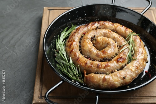 Tasty homemade sausages with spices on grey table