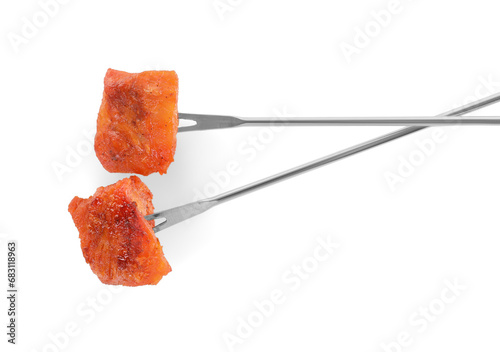 Fondue forks with pieces of fried meat isolated on white