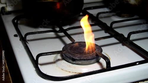 Lit gas burner. Faulty knob. Cooking food. Fire in the house. Kitchen stove. Flame in household terms. Orange flame on stoves in the kitchen