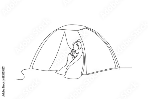 One line depicts a camping landscape in a campground. A woman who is warming herself with a blanket and hot drink in front of the tent. Eco-friendly tourism. Continuous line drawing design vector illu