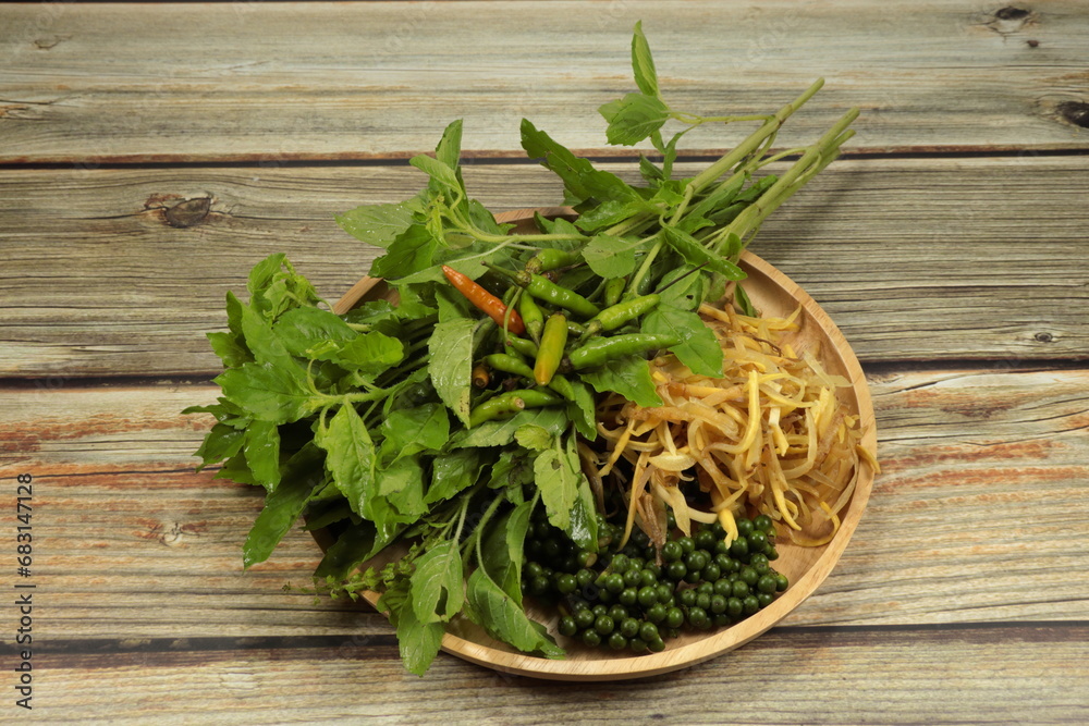 Pile of fresh and organic Thai local spices and herbal vegetable on the wooden tray. Famous local ingredient product in Thai kitchen. Pile of fresh and organic Thai local spices and herbal vegetable on the wooden tray. Famous local ingredient product in Thai kitchen.