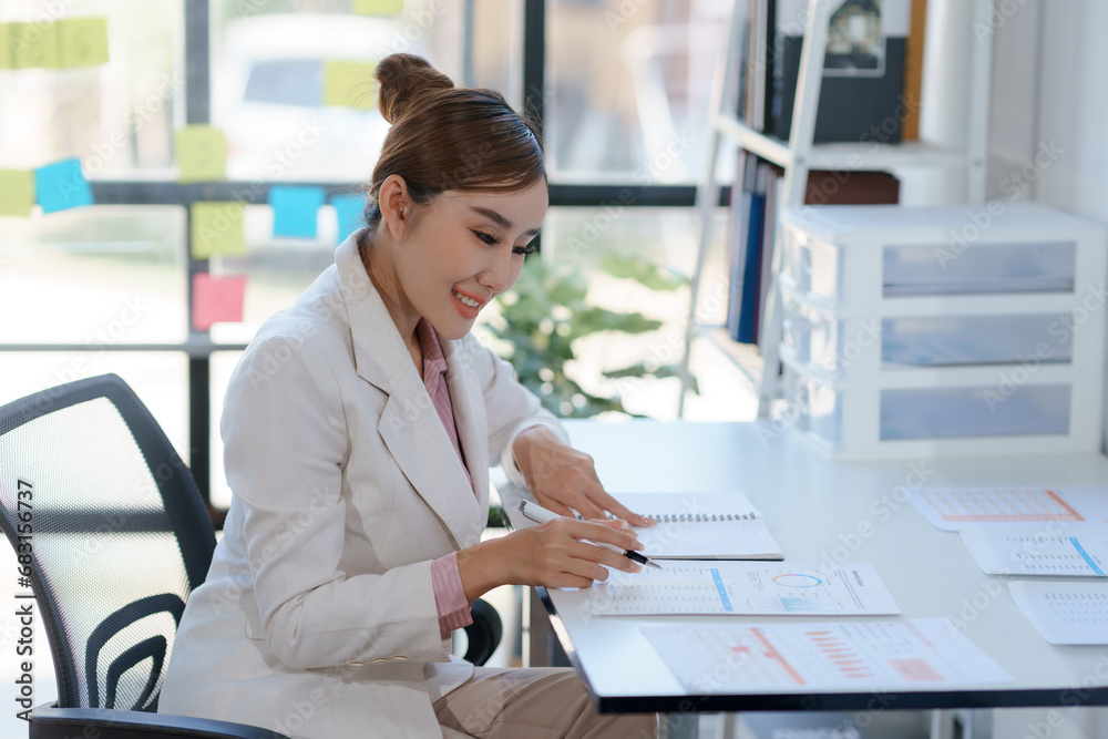 Young Asian businesswoman working document and project in modern office. Financier working with documents at workplace. Young Asian businesswoman working document and project in modern office. Financier working with documents at workplace.