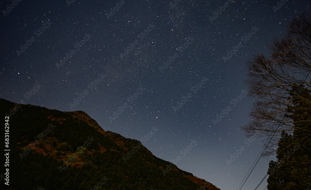 紅葉の山に昇る天の川と満天の星空