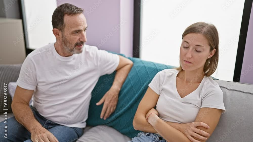 Unhappy father and daughter locked in a heated argument while sitting on the sofa at home, their love stretched thin amid this family disagreement Unhappy father and daughter locked in a heated argument while sitting on the sofa at home, their love stretched thin amid this family disagreement
