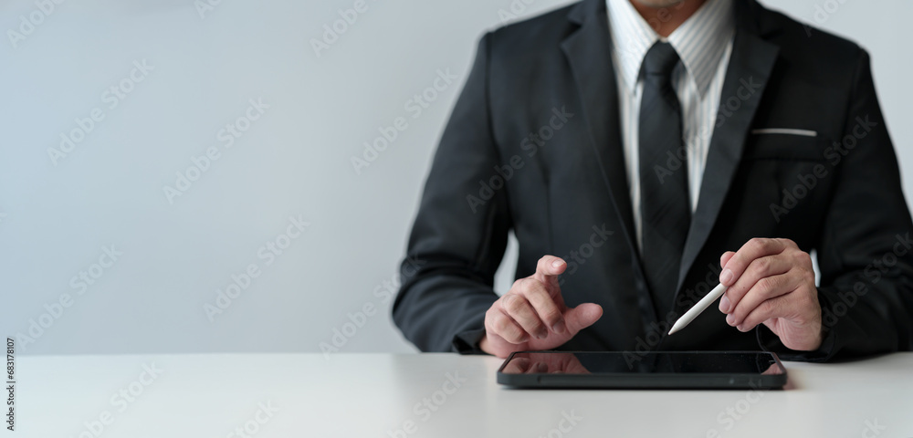 Businessman working on laptop computer and tablet on table at office. Working online. Using pen, index finger on digital tablet screen. Startup business idea. Copy space, banner, panorama Businessman working on laptop computer and tablet on table at office. Working online. Using pen, index finger on digital tablet screen. Startup business idea. Copy space, banner, panorama