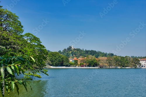 KANDY, SRI LANKA - FEBRUARY 10, 2021: View on Kandy lake and big Buddha on top of the hill. Kandy is home of The Temple of the Tooth Relic, one of the most sacred Buddhist places of worship. 