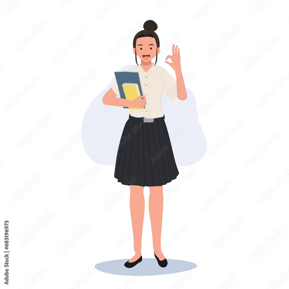 Thai University Student in Uniform Holding Books and doing OK hand sign gesture Thai University Student in Uniform Holding Books and doing OK hand sign gesture