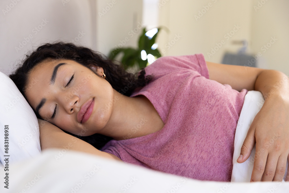 Biracial woman sleeping in bed at sunny home Biracial woman sleeping in bed at sunny home