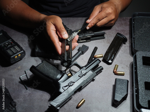 Canvas Print Gunsmith cleaning pistol Assemble, dismantle, and maintain with a brush to clean a black 9 mm pistol on an old cement floor pattern table