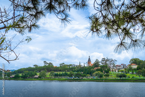 Fototapeta Naklejka Na Ścianę i Meble -  Aerial view of a Da Lat City with development buildings, transportation. Tourist city in developed Vietnam. Center Square of Da Lat city with Xuan Huong lake and market.