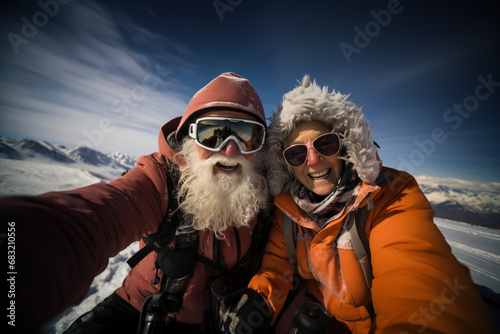 Selfie portrait of senior active smiling mature couple snowboarding skiing in glasses look happy on top of mountains winter day time, happily retired. Active sport elderly healthy lifestyle concept