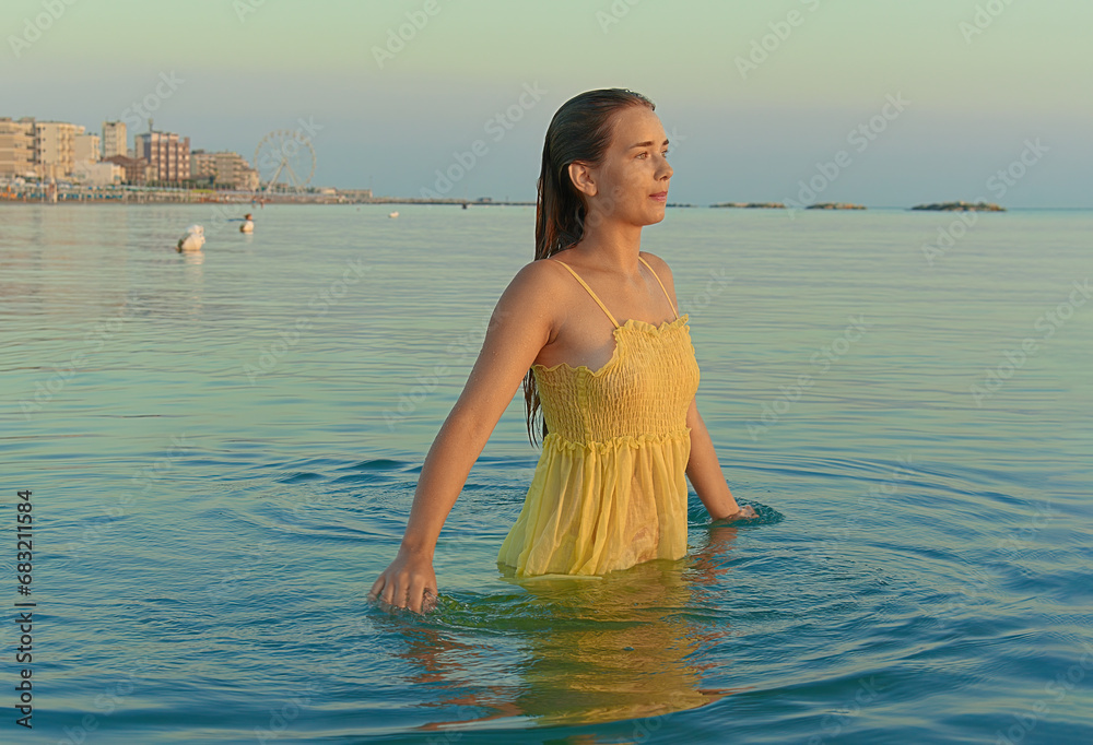 Young female traveler posing on the beach by the sea at sunrise and sharing her adventure travel. Young female traveler posing on the beach by the sea at sunrise and sharing her adventure travel.