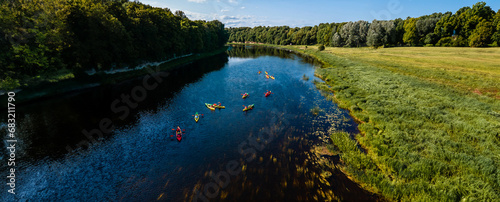 Kayakers enjoying a peaceful paddle on a calm river amidst expansive countryside