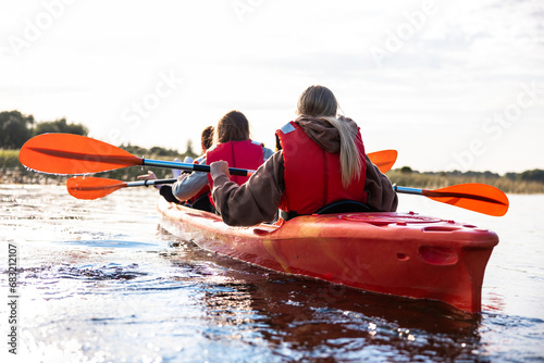 Adventurous kayakers exploring a river during boat trip in summer