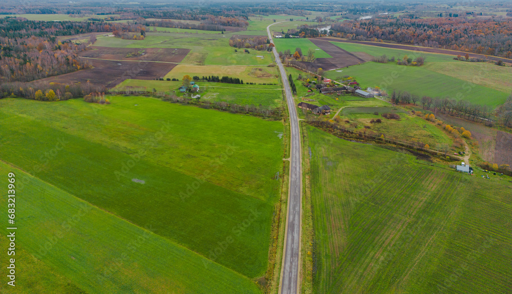aerial view on the highway between agricultural green fields