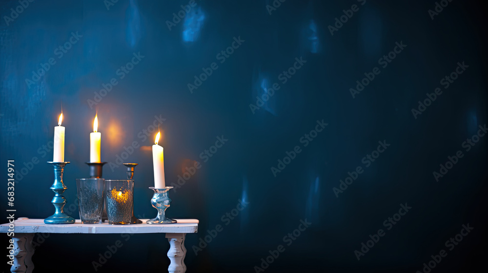 candlesticks with burning candles on dark blue background 