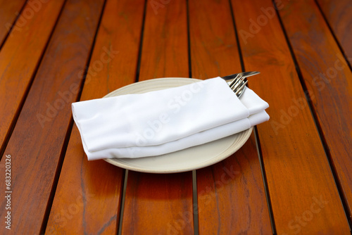 knife with fork and spoon in napkin on white plate