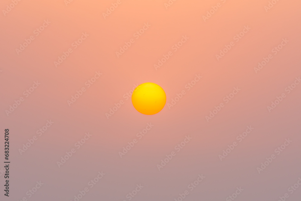 yellow orange sun on orange sky during sunset in the summer