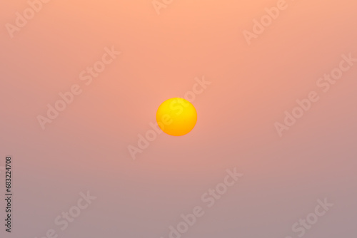 yellow orange sun on orange sky during sunset in the summer