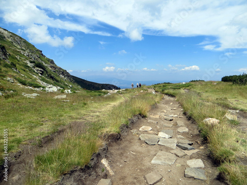 Rila, Bulgaria. August 02,2023. Summer. Sunny day. Picturesque view of the mountain Rila. The hiking trail passes towards the horizon with tourists in the background.