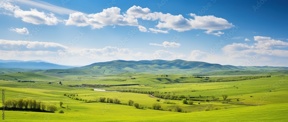 Beautiful landscape with green meadows and blue sky with clouds.