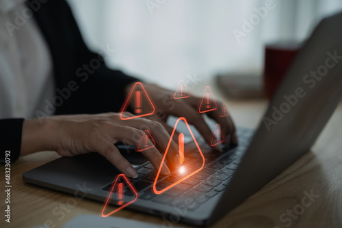 Businesswoman using laptop showing virtual screen icon caution warning triangle and exclamation sign icon Warning of dangerous problems Server error. Virus. Internet network security concept.