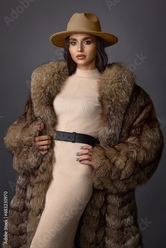 Принти на полотні a young girl with exquisite makeup in a beige tight-fitting dress, hat and fur c