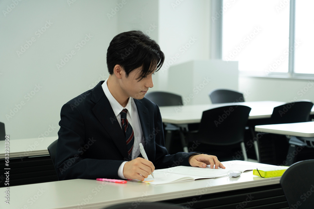 教室で勉強している制服の10代の少年 教室で勉強している制服の10代の少年