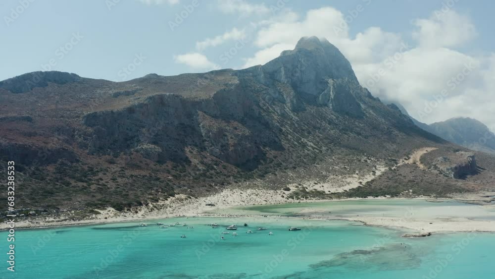 Aerial drone shot of mountain on the coast with clouds around the peak Aerial drone shot of mountain on the coast with clouds around the peak