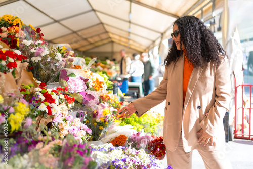 Latin woman walking around a street market with flower shop