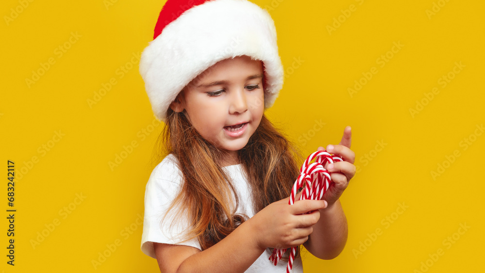 Happy child girl is holding Christmas candy canes. Happy little girl happy on the eve of Christmas. New Years Eve. Happy child girl is holding Christmas candy canes. Happy little girl happy on the eve of Christmas. New Years Eve.
