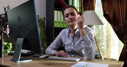 Nervous businesswoman in office biting nails and working on computer. Nail biting onychophagia causes symptoms