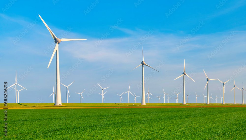Windmill park with windmill turbines in the Netherlands, green energy with a green agriculture field of grass in the foreground, Energy transition clean energy concept Windmill park with windmill turbines in the Netherlands, green energy with a green agriculture field of grass in the foreground, Energy transition clean energy concept