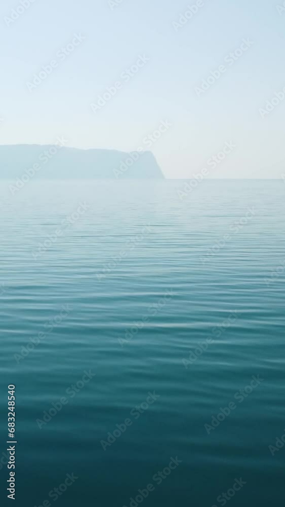 Abstract aerial calm sea summer ocean sunset nature. Small waves on water surface with clear blue sky. Holiday, vacation and recreational concept. Weather and Climate Change. Nobody. Vertical video Abstract aerial calm sea summer ocean sunset nature. Small waves on water surface with clear blue sky. Holiday, vacation and recreational concept. Weather and Climate Change. Nobody. Vertical video