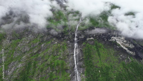 Cinematic aerial view of waterfall flowing glacier melt down in the Fjords of Norway photo