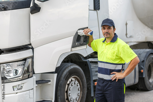 Male truck driver standing by door of vehicle while looking at camera © Juan Algar