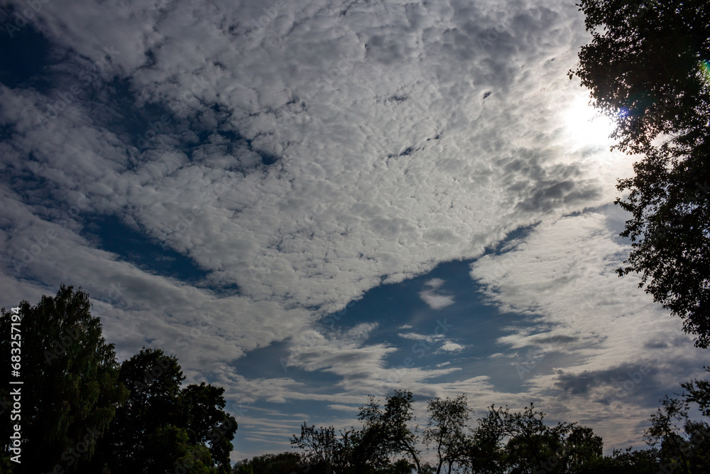 Altocumulus clouds on a blue sky illuminated by the sun