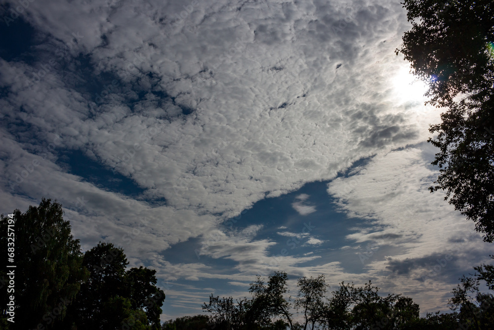 Obraz premium Altocumulus clouds on a blue sky illuminated by the sun