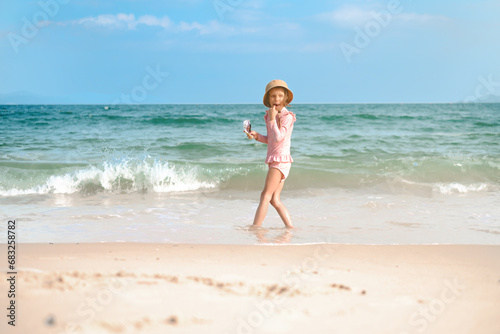 A child girl 6 years old plays on the beach with waves. One preschool-age girl on the seashore