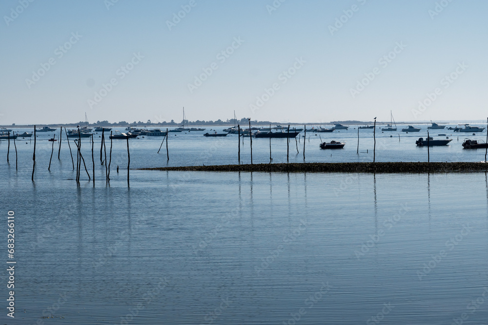 View on Arcachon Bay at low tide with many fisherman's boats and oysters farms, Cap Ferret peninsula, France, southwest of Bordeaux along France's Atlantic coastline